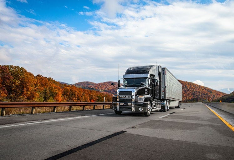 A semi truck driving on a highway Description automatically generated with medium confidence